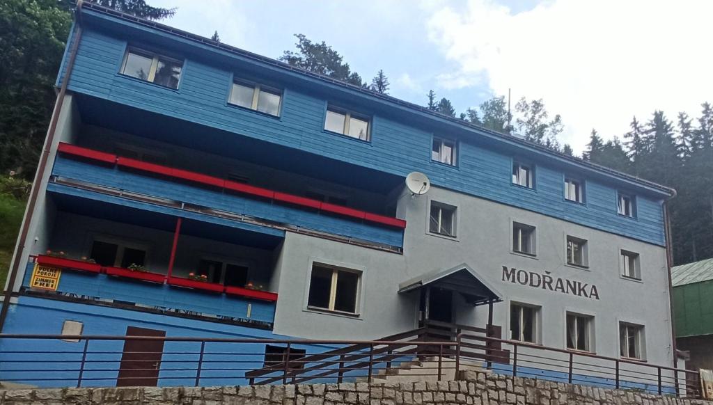 Penzion Modřanka في بيك بود سنيزكو: مبنى أزرق كبير مع كلمات monngahela