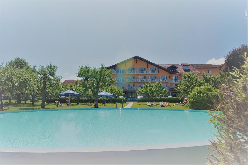 a large swimming pool in front of a building at Hotel Pachernighof in Velden am Wörthersee