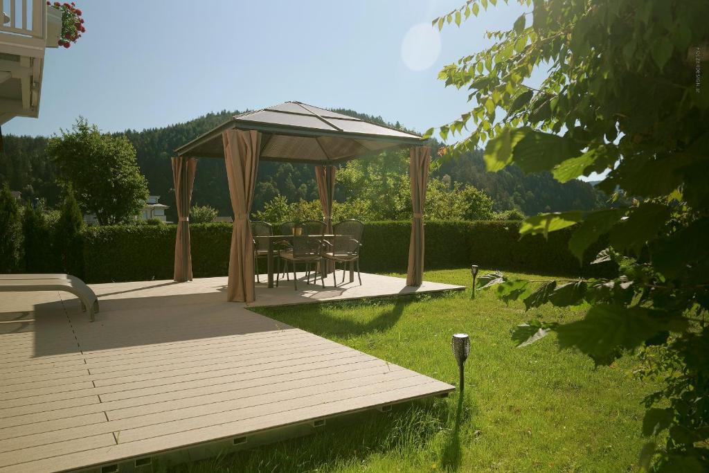 a wooden deck with a gazebo in a yard at Hotel Pachernighof in Velden am Wörthersee
