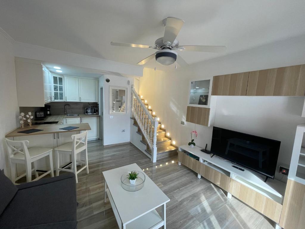 Il comprend un salon et une cuisine avec un canapé et une table. dans l'établissement Apartamento Gustamar 11, à Caleta de Fuste