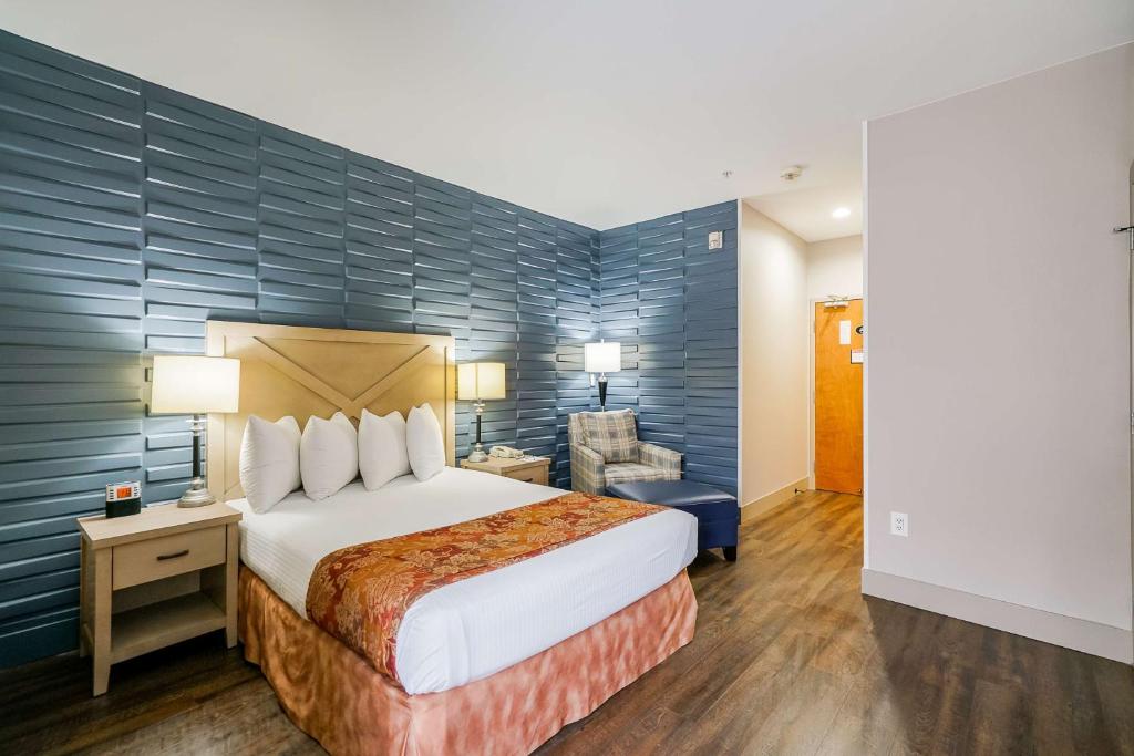 a hotel room with a bed and a chair at Best Western Peace Arch Inn in Surrey