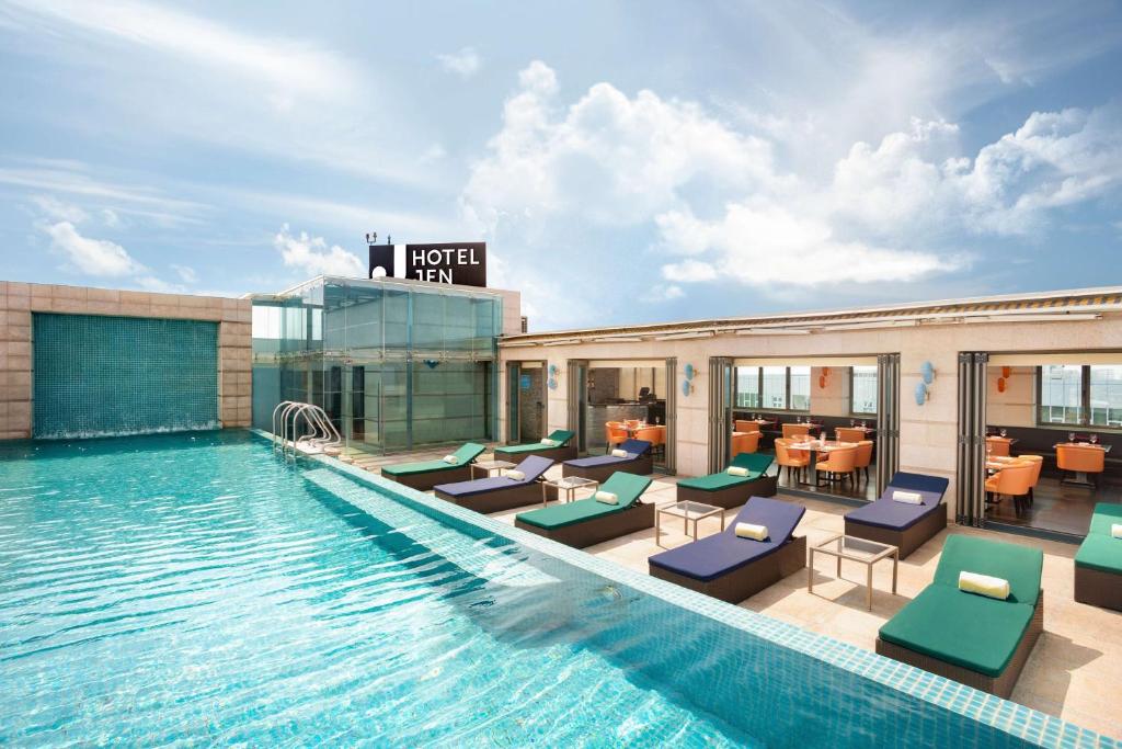 Jen Maldives Male by Shangri-La في مدينة ماليه: مسبح الفندق مع كراسي الجلوس والمطعم