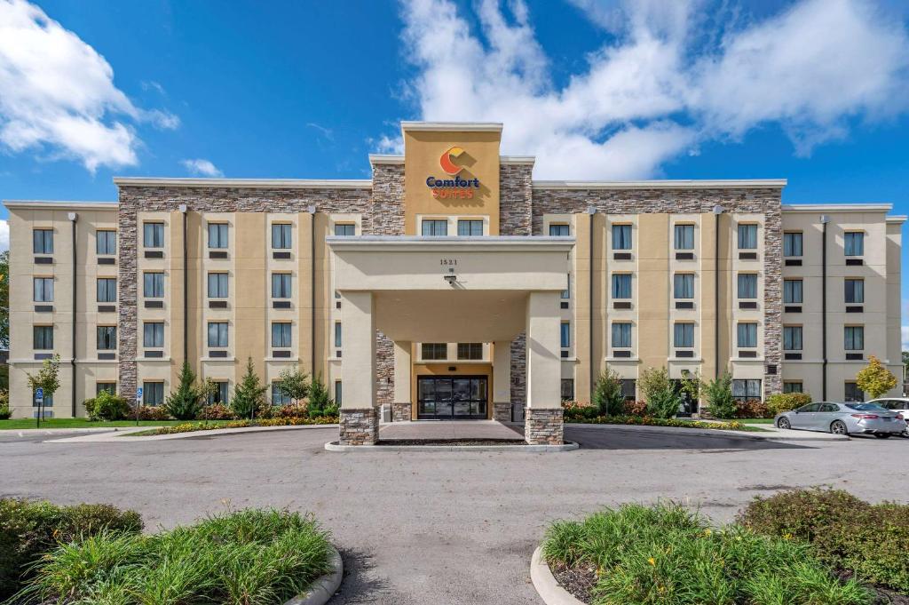 a large tan building with a sign on the front at Comfort Suites Columbus Airport in Columbus