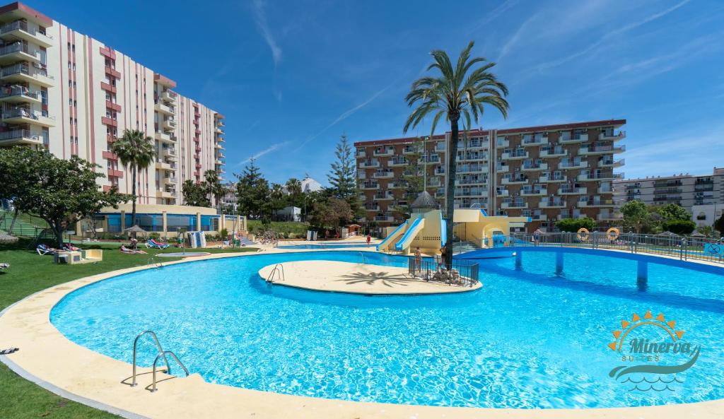 a large swimming pool with a slide in front of some buildings at Júpiter Suites by Kaarina in Benalmádena