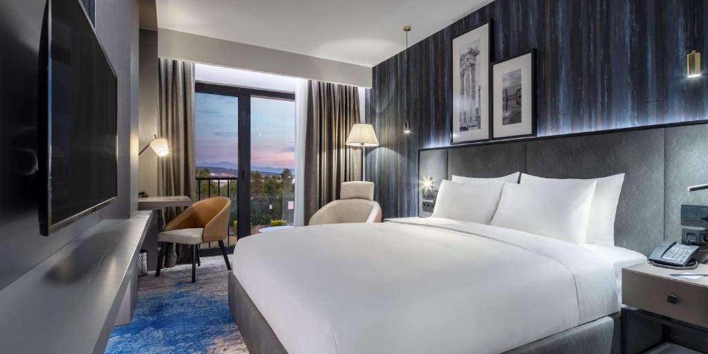 Un pat sau paturi într-o cameră la Radisson Hotel Izmir Aliaga