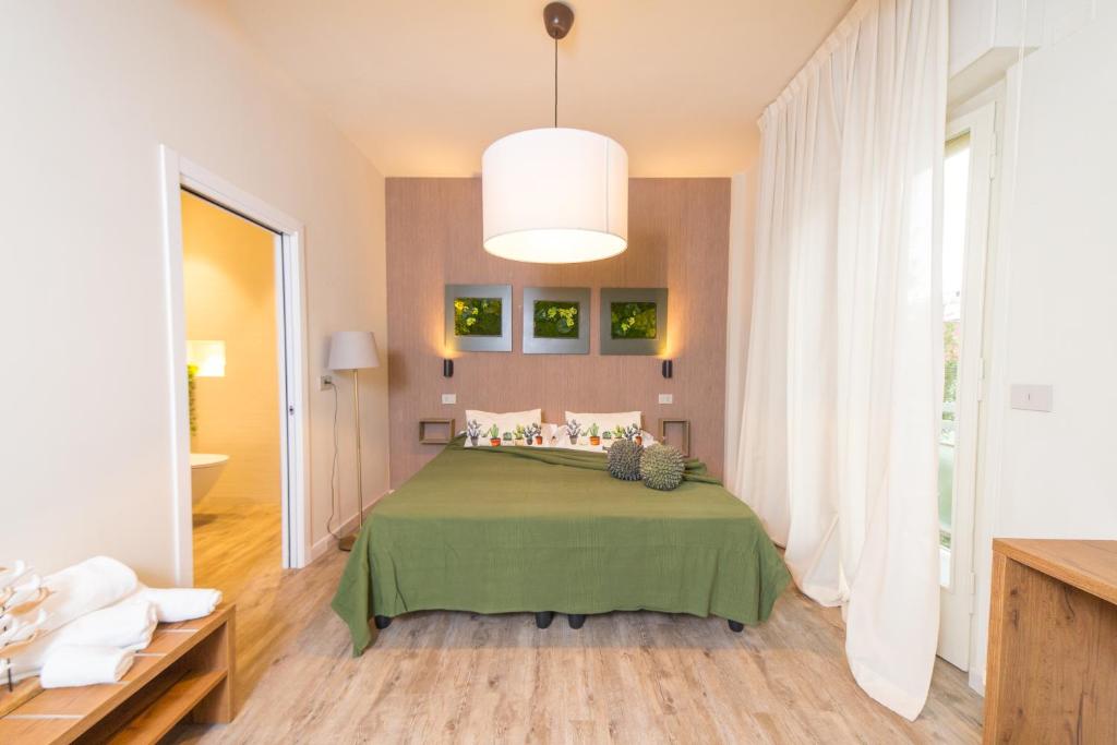 ein Schlafzimmer mit einem Bett mit einer grünen Decke in der Unterkunft Hotel Rex in Gabicce Mare