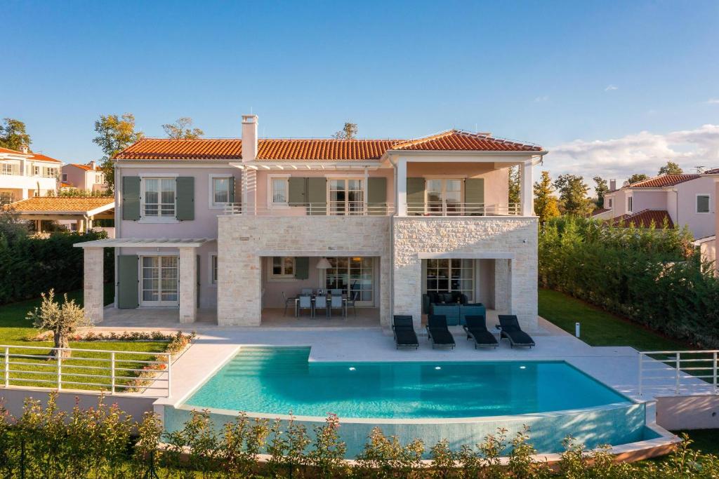 a house with a swimming pool in front of it at Villa Blanche by ILC (Istria Luxury Collection) in Brtonigla