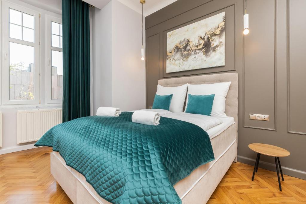 a bedroom with a large bed with a green blanket at Sopot RIVOLI Apartments by Renters in Sopot