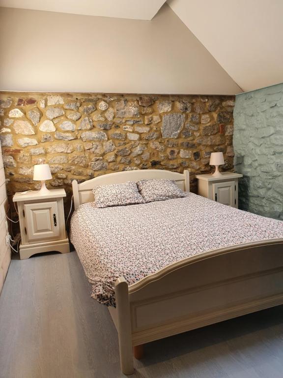 a bedroom with a bed and two night stands with lamps at Au pti fayt in Barbençon