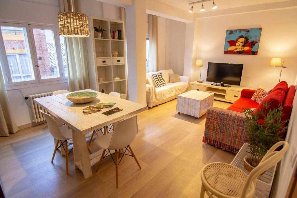 un soggiorno con tavolo e divano di HabitaHost Ramón y Cajal a Cuenca