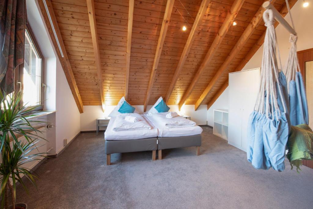a room with two beds and a wooden ceiling at FeWo Immenstaad 2 in Immenstaad am Bodensee