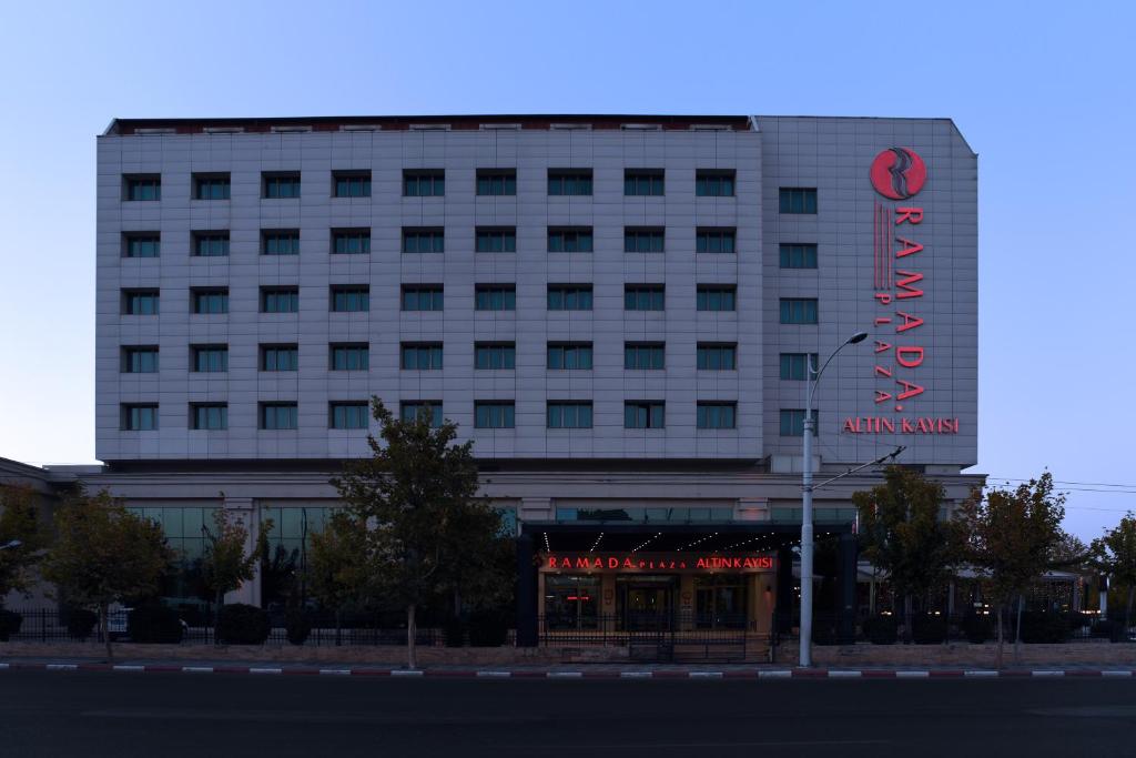 マラティヤにあるRamada Plaza Altin Kayisi Hotelのアラミノスホテルを読む看板のある建物