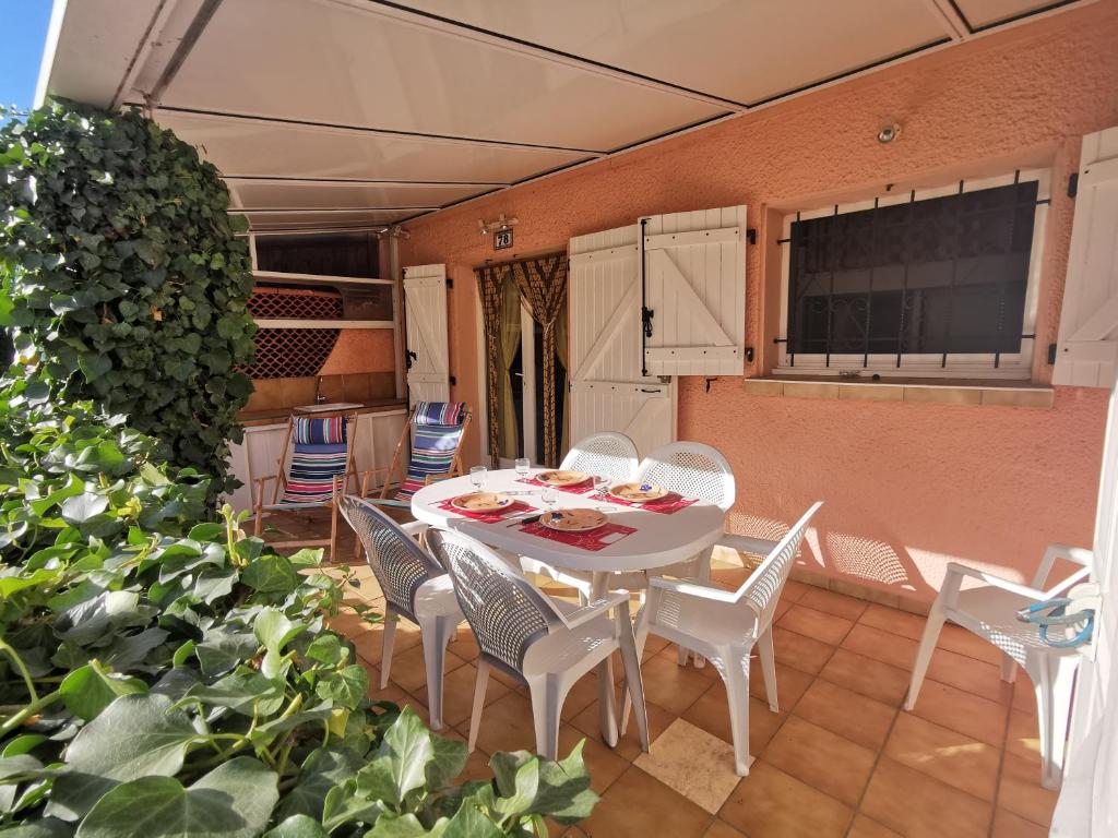 una mesa blanca y sillas en un patio en Les Lavandines -Coquette Maison de Vacances - 400 m de la plage - Grande Terrasse - 2 chambres - 2 salles de bain - Tout confort en Argelès-sur-Mer