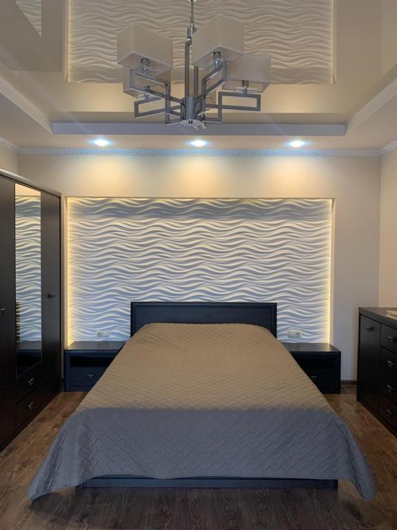 ein Schlafzimmer mit einem Bett und einem großen Wandgemälde in der Unterkunft Затишні сучасні апартаменти в елітному ЖК Версаль in Truskawez