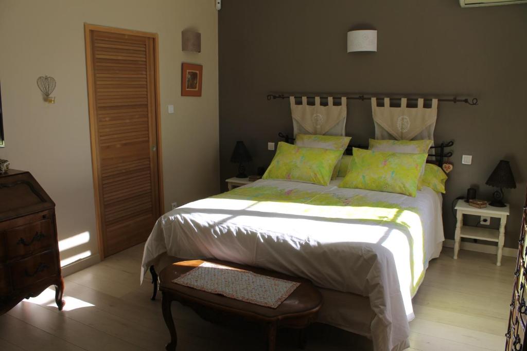 een slaapkamer met een groot bed met groene kussens bij Lou Bastido in Marseille