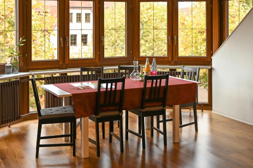 comedor con mesa, sillas y ventanas en FeWo Immenstaad 1, en Immenstaad am Bodensee