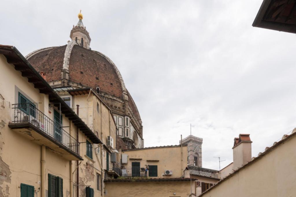 an old building with a dome on a street at Apartments close to Duomo in Florence