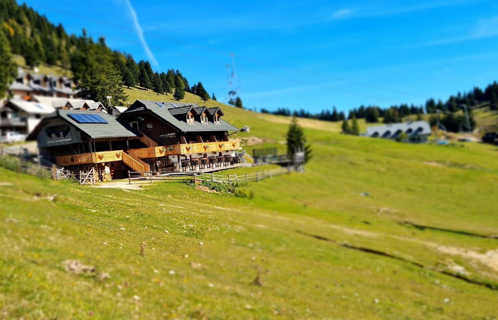 een groot huis op een heuvel in een groen veld bij EkoTurizem Viženčar in Cerklje na Gorenjskem