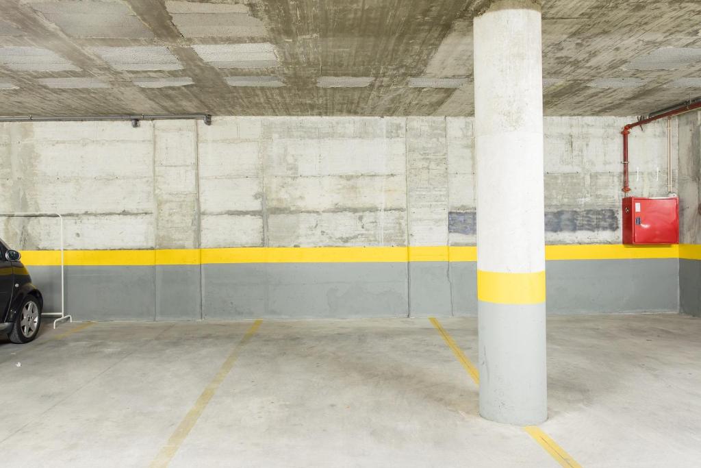 a parking garage with a white pole and a car at Beach House Ericeira in Ericeira