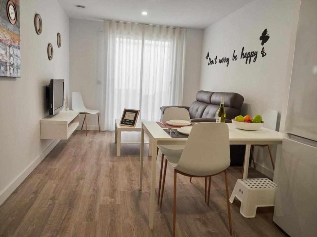 a living room with a table and a dining room at San José Apartamentos Turísticos Karlie in Albacete