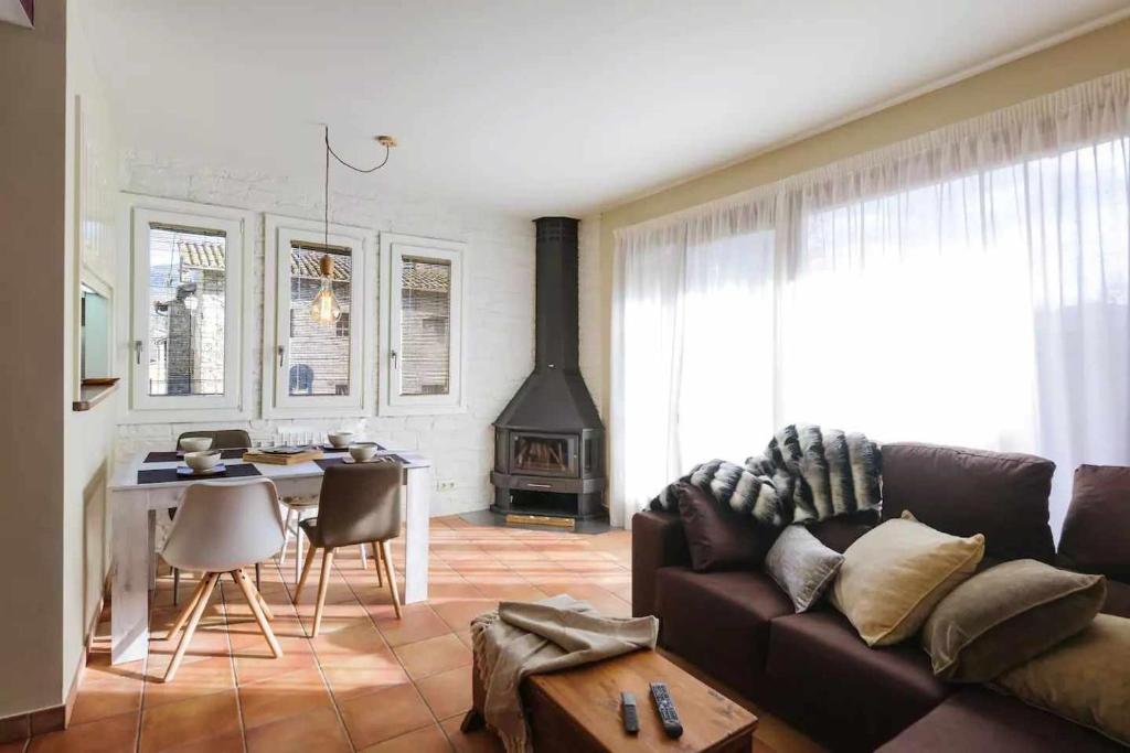 a living room with a couch and a table and a fireplace at Apartamento Can Trona 1B Turismo volcánico Vall de Bas in Joanetes