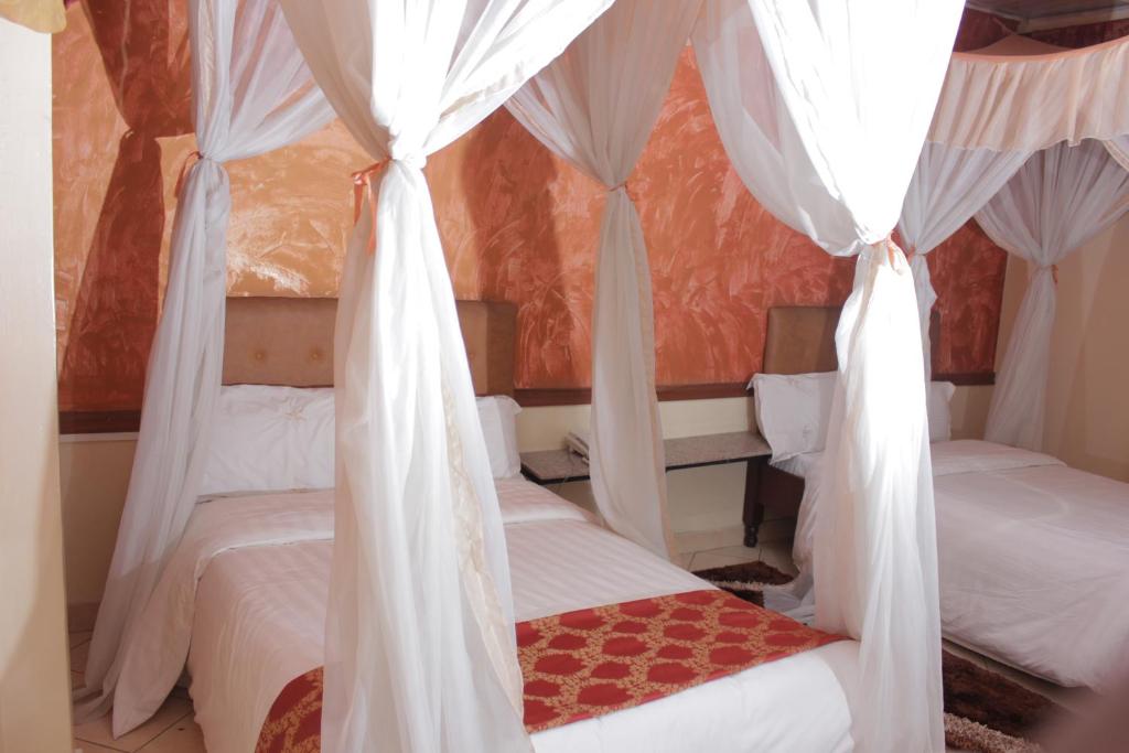 Postel nebo postele na pokoji v ubytování Pearl Palace Hotel