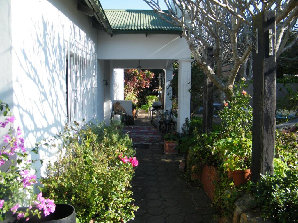 un porche de una casa con flores y plantas en Valley Guest House en Puerto Elizabeth
