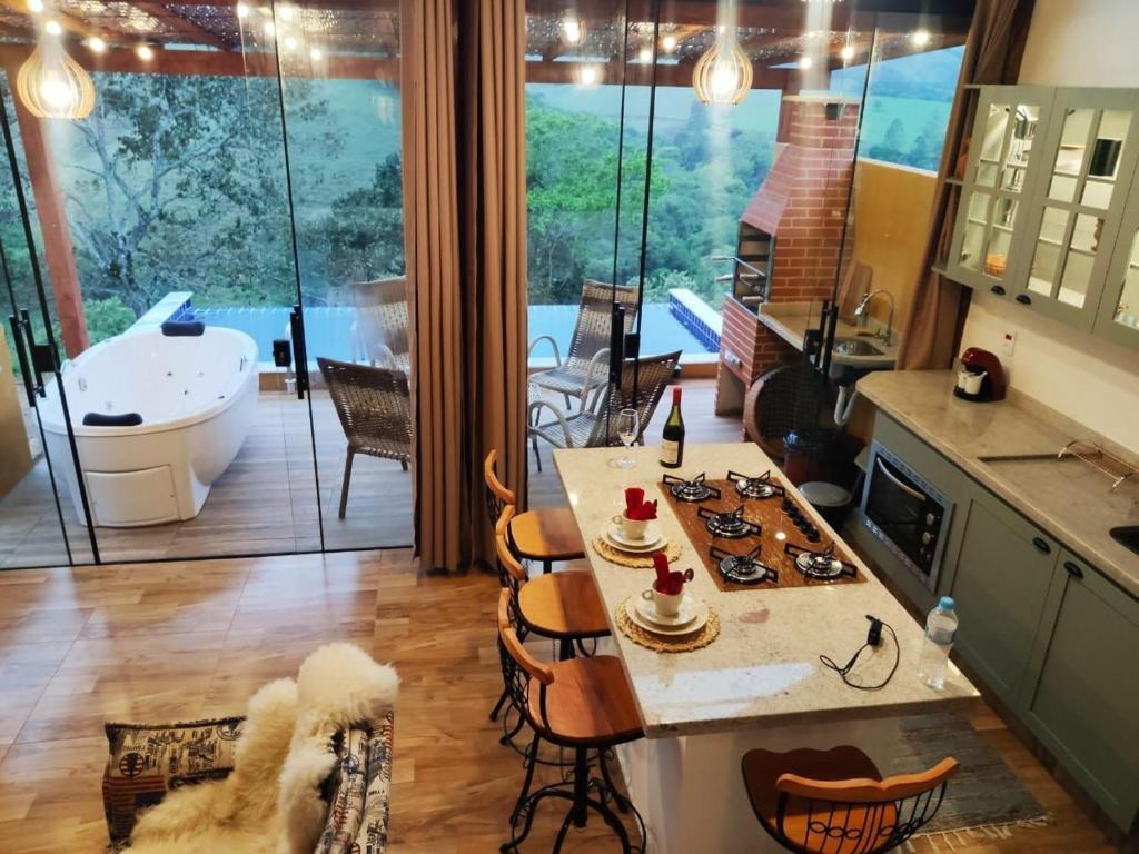 a kitchen with a table and chairs and a tub at Chalé Arara super Luxo in Cunha