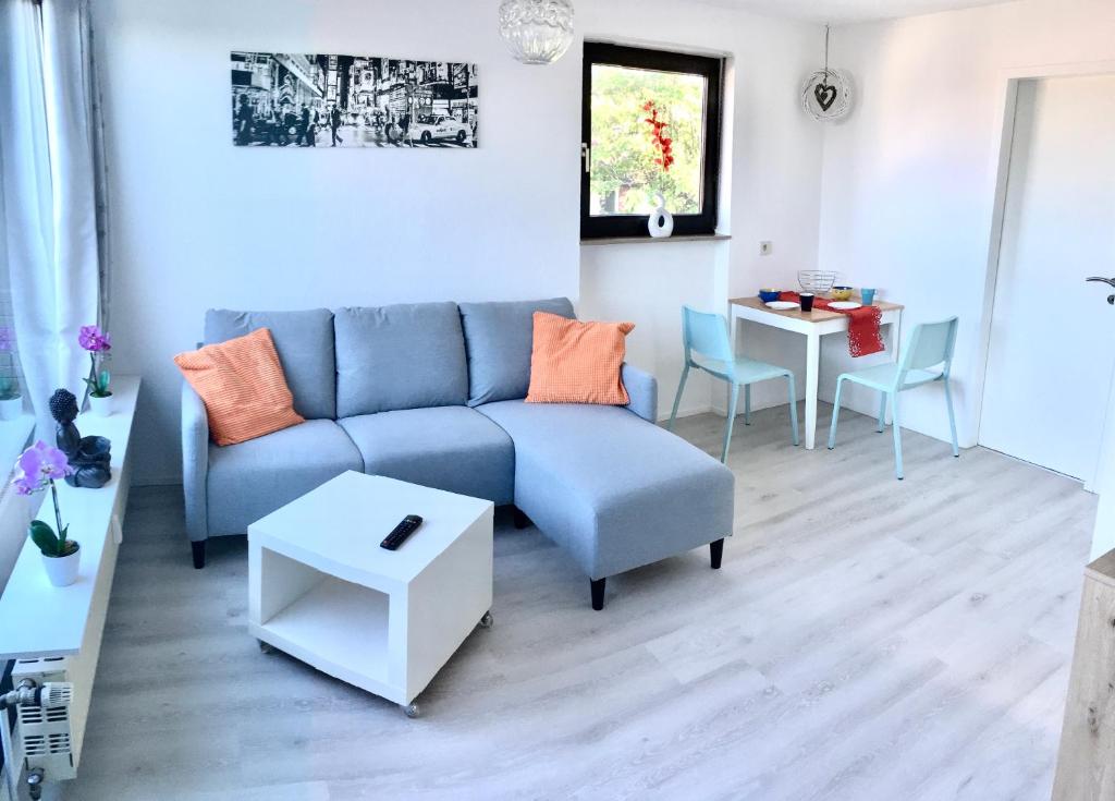 a living room with a blue couch and a table at Ferienwohnung Bellevue in Saarbrücken