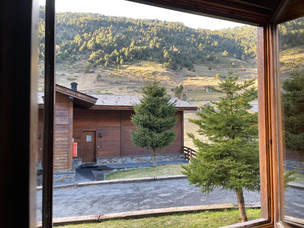 una ventana con vistas a una casa en CABANA SORDA - Peu del Riu 302 - Vall d'Incles - Soldeu, en Incles