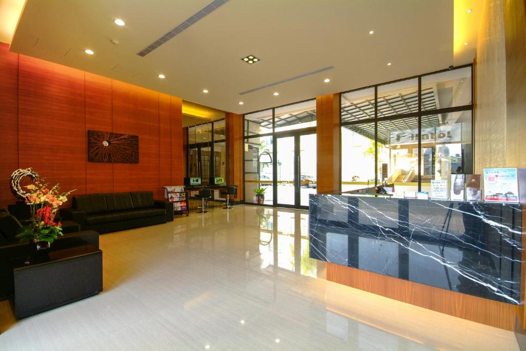 a lobby of a building with a couch and a counter at F Hotel Tainan in Tainan