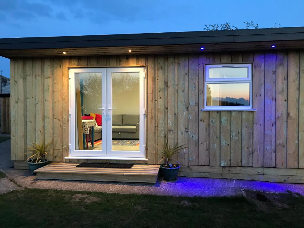 Casa de madera con puerta corredera de cristal en Kingfisher Glamping Cabin, en Bodmin