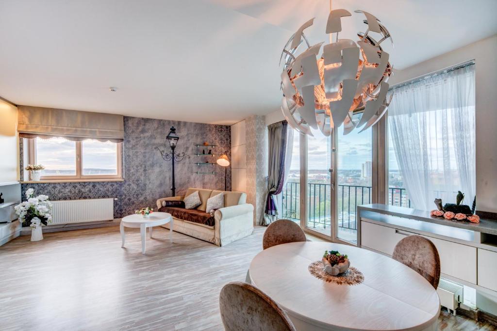 a living room with a table and a chandelier at Apartment near center in Klaipėda