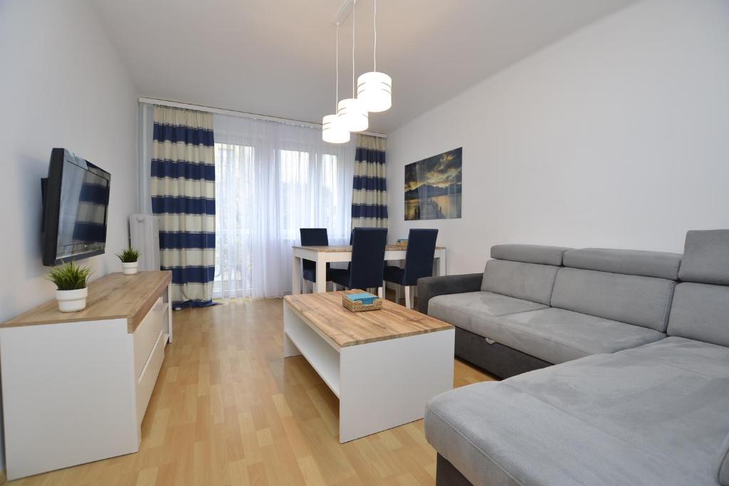 a living room with a couch and a table at Apartament Błękitny-Centrum Racibórz in Racibórz
