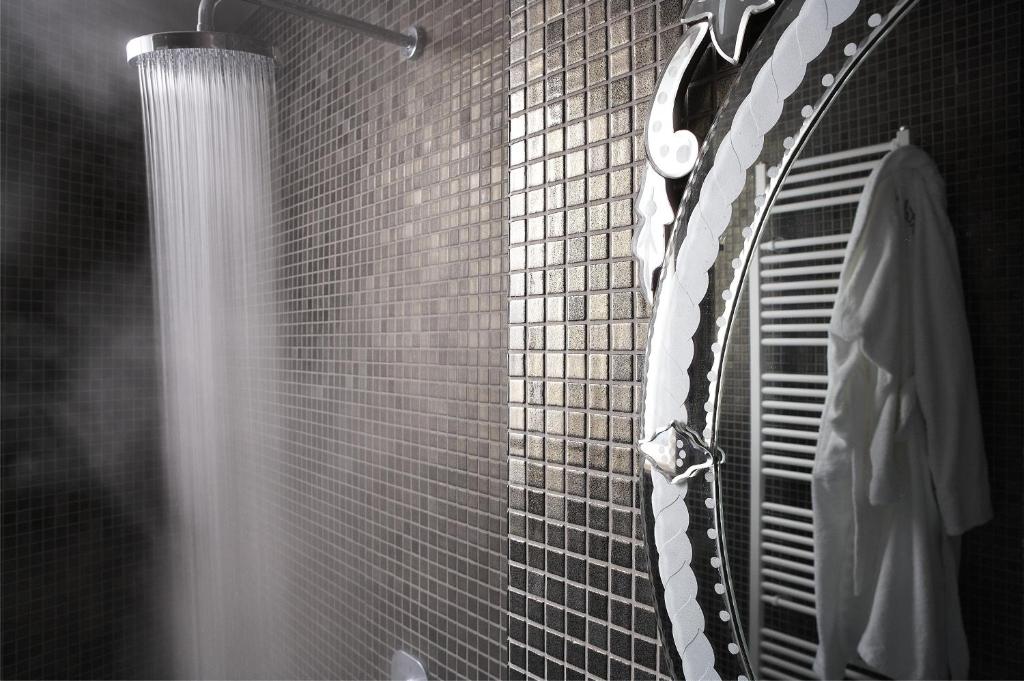 La salle de bains est pourvue d'une douche et d'une cravate noire et blanche. dans l'établissement Art Hotel Mirtali, à Dodoni