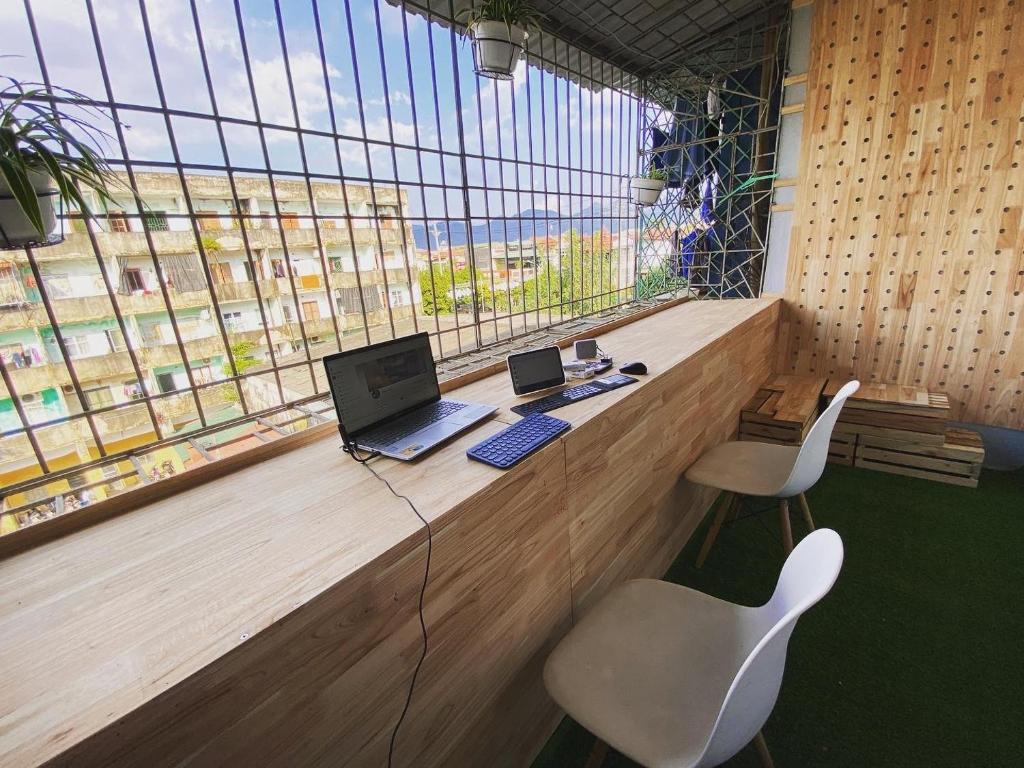 a office with a desk with a laptop and two chairs at 3cuhomestay in Thinh Làng