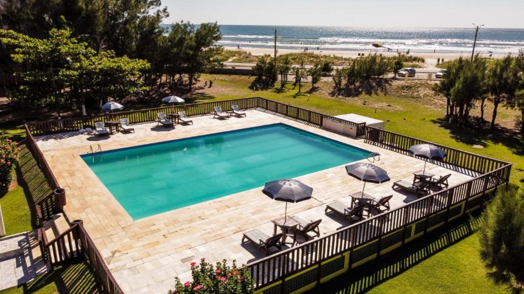 an overhead view of a swimming pool with chairs and umbrellas at Ravena Cassino Hotel in Laguna