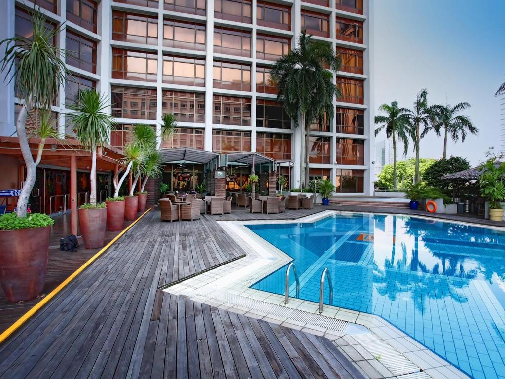 a large swimming pool with a balcony overlooking the ocean at Village Hotel Bugis by Far East Hospitality in Singapore