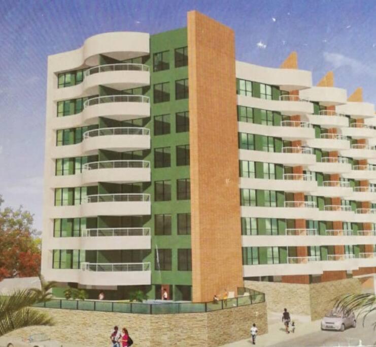 阿塔卡梅斯的住宿－Suites Marbensa, Malecón de Atacames，一座高大的建筑,前面的人在步行