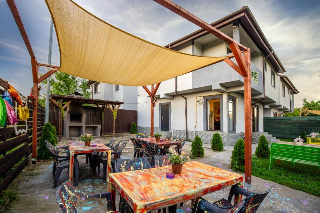 une terrasse avec des tables et des chaises en face d'une maison dans l'établissement Vila Petreceri Private, à Boltaşi