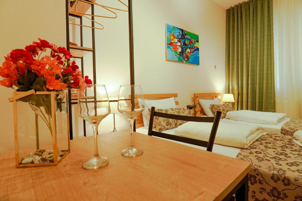 Habitación con mesa y 2 copas de vino en Check-In Hotel, en Tiflis