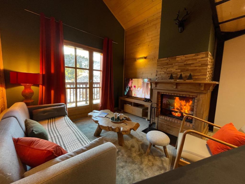 un soggiorno con divano e camino di Duplex - 4 personnes ARC 1950 ad Arc 1950