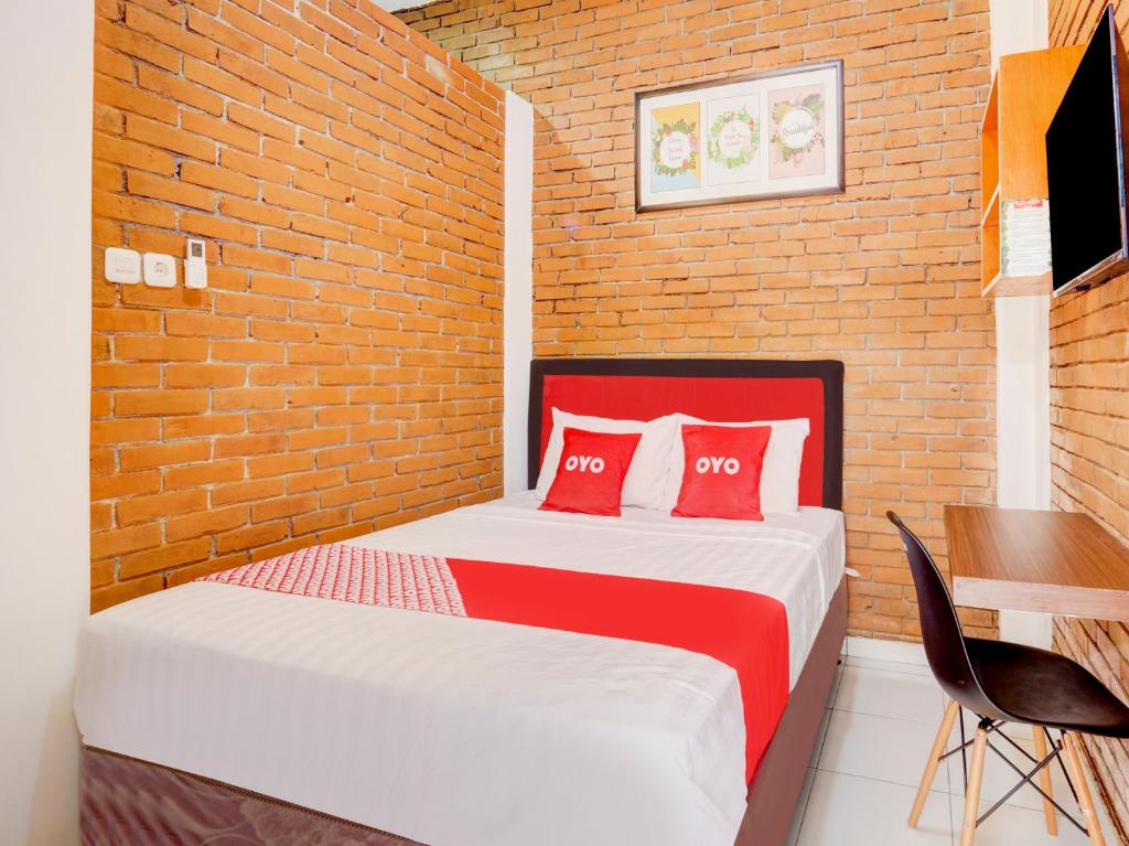 een slaapkamer met een bed en een bakstenen muur bij SUPER OYO 90758 D Kost In Kandri Semarang Syariah in Semarang