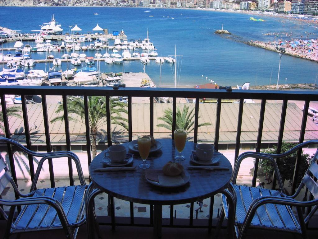 a table on a balcony with a view of a marina at Hotel Condestable in Benidorm