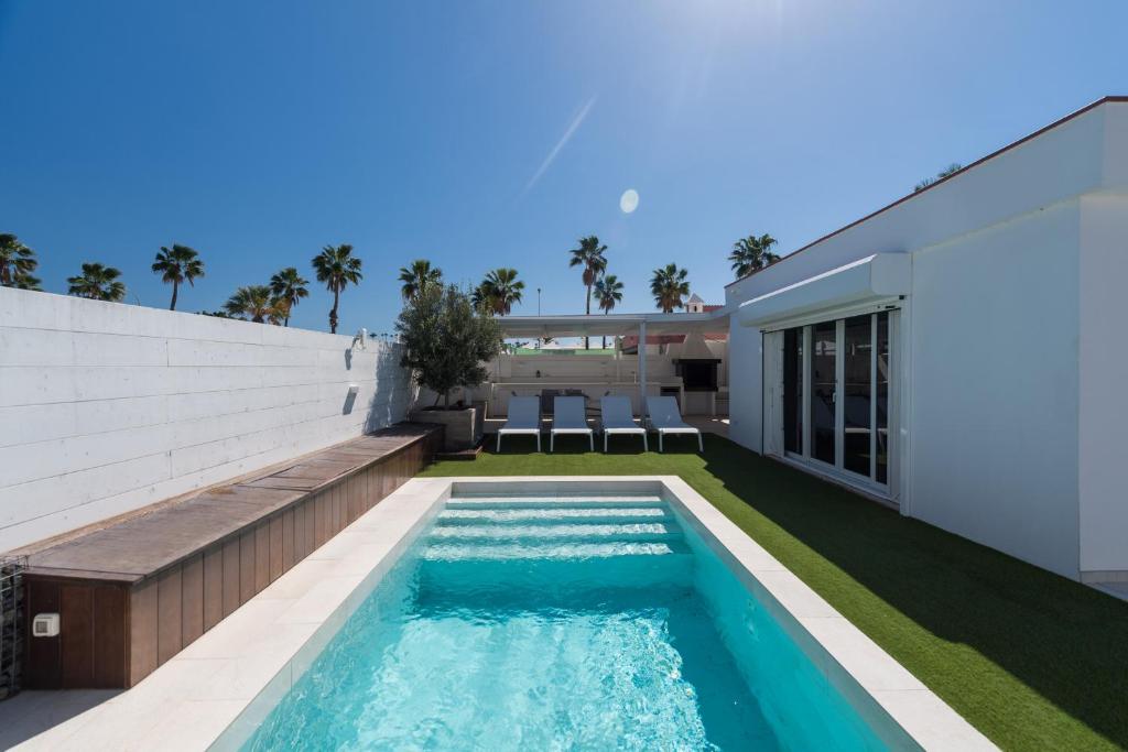 馬斯帕洛馬斯的住宿－Casa Maspalomas private pool, Bbq and private parking，一座房子后院的游泳池