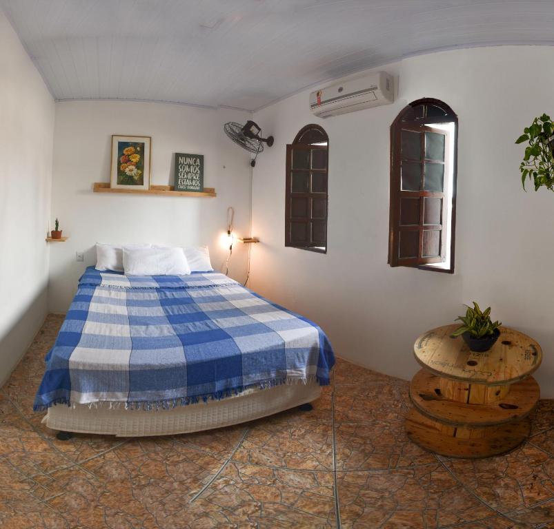 a bedroom with a blue and white bed and a table at Puleiro Hostel in Salvador