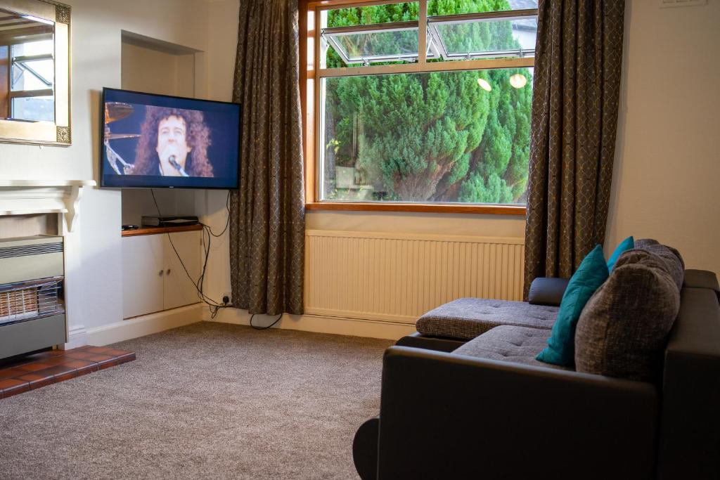 a living room with a couch and a flat screen tv at Lovely self-catering apartment in city centre in Dumfries