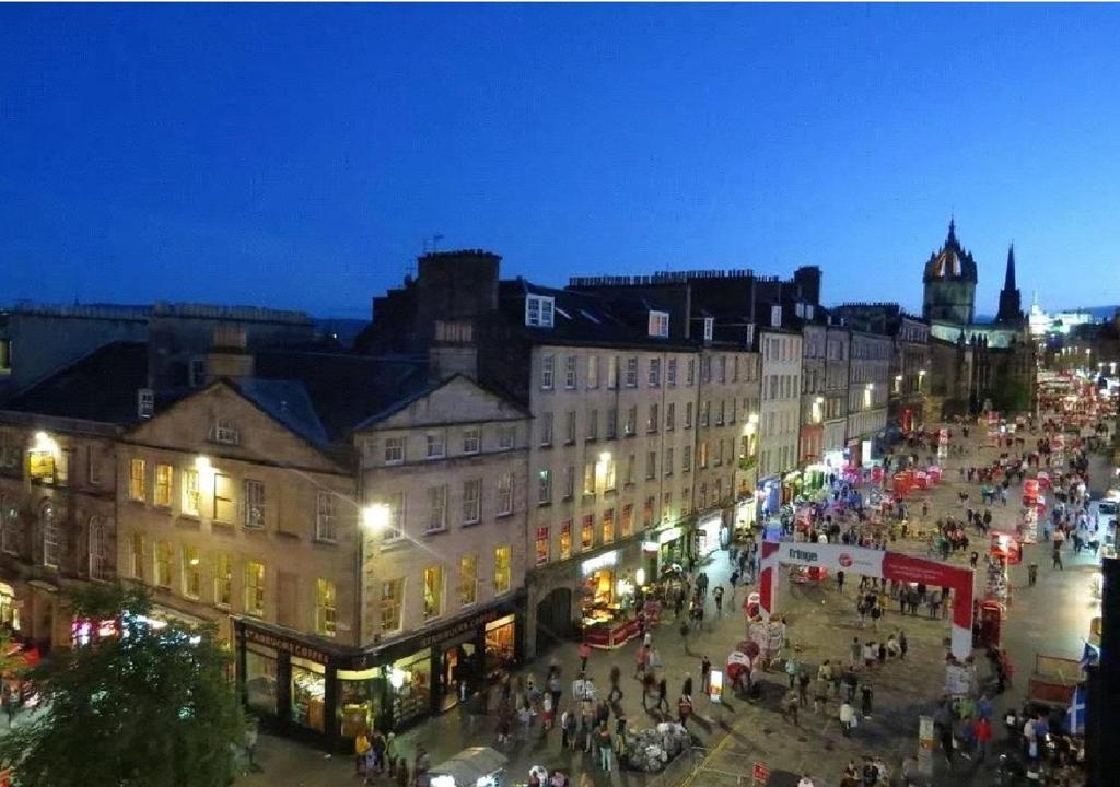 a city street at night with a crowd of people at Royal Mile View in Edinburgh