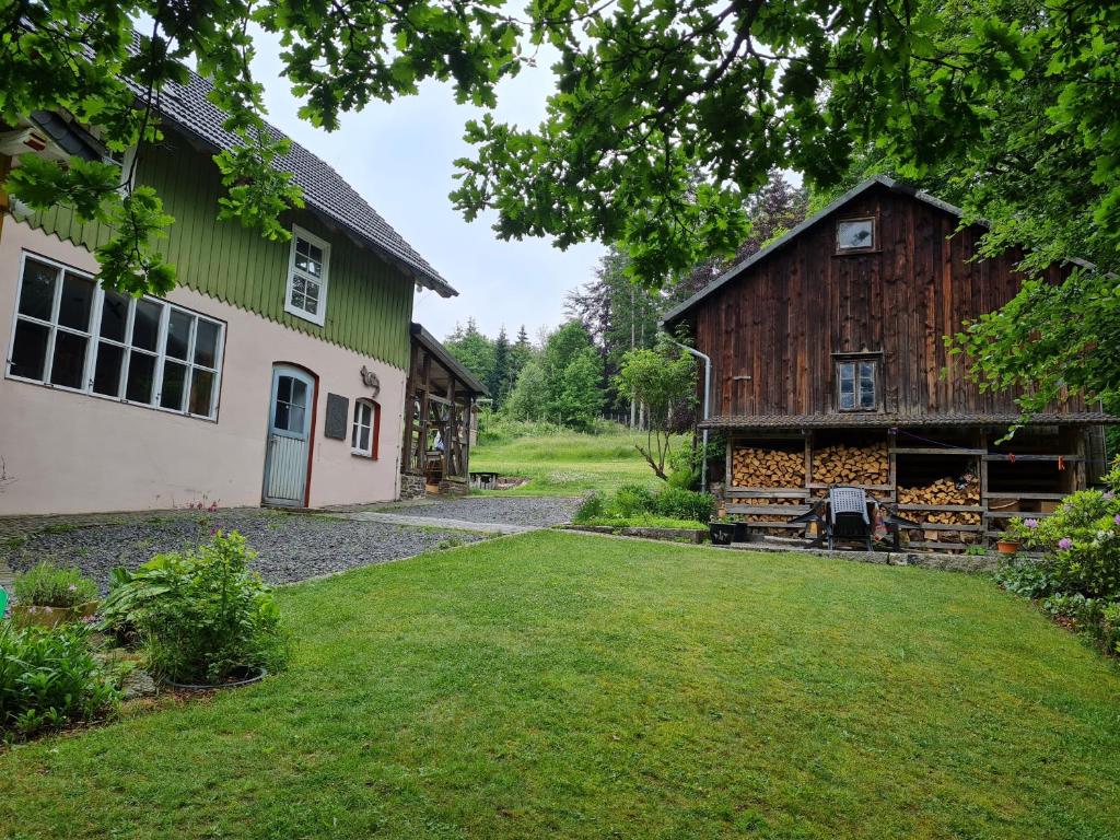 un granero y una casa con un patio en Ferienwohnung im Wald, für Naturfreunde, en Clausthal-Zellerfeld