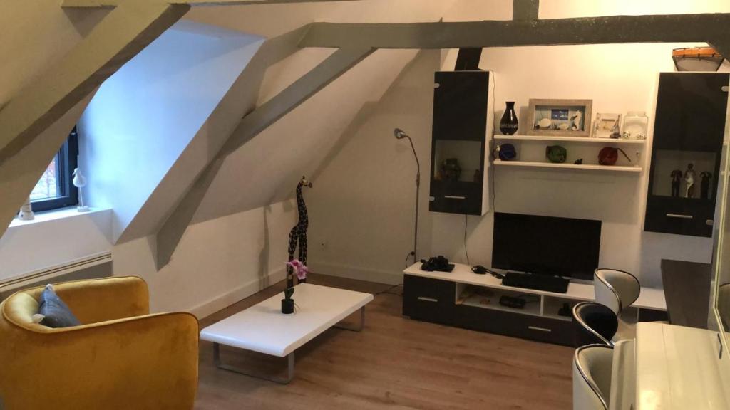 ein Wohnzimmer mit einem Sofa und einem TV in der Unterkunft Logement entier sur Wormhout in Wormhout
